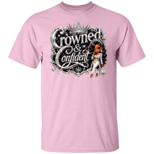 A light pink short-sleeve crewneck t-shirt featuring a large graphic print on the front. The graphic displays the text 'Crowned & Confident' in a stylized silver font with a crown above, alongside an illustration of a woman in a white outfit holding a handbag.