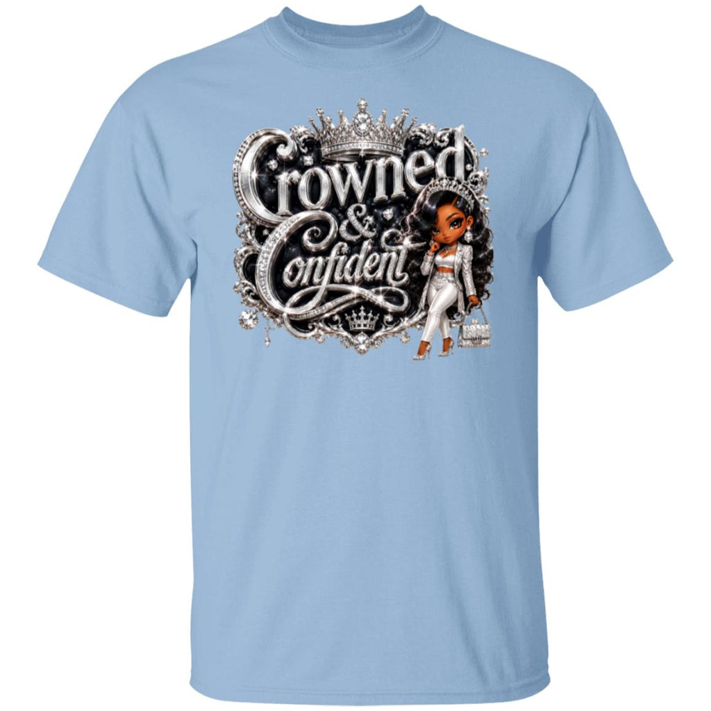 A light blue short-sleeve crewneck t-shirt featuring a graphic print on the front with the words 'Crowned & Confident' in ornate silver lettering, topped with a crown, and accompanied by an illustration of a woman in a white outfit.