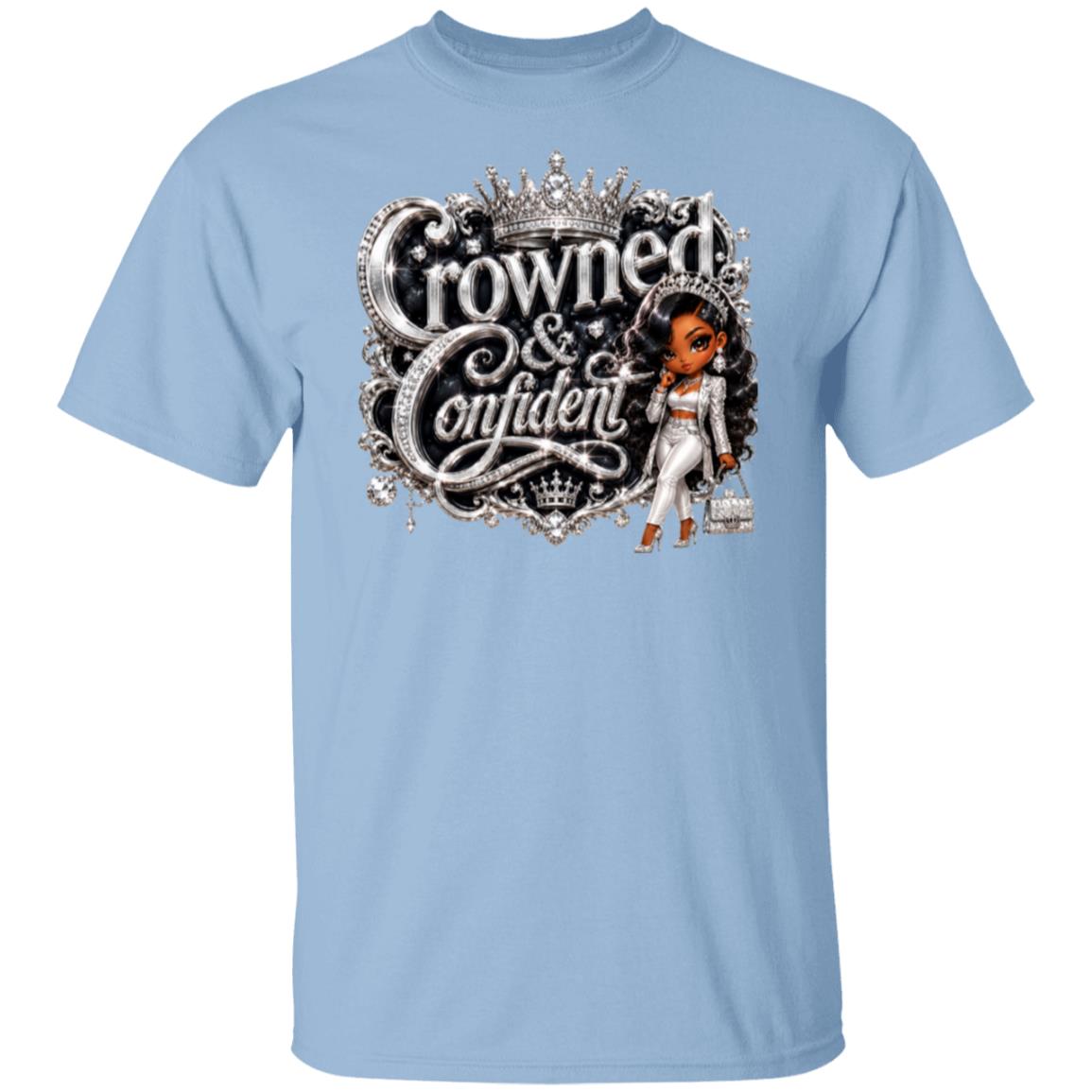 A light blue short-sleeve crewneck t-shirt featuring a graphic print on the front with the words 'Crowned & Confident' in ornate silver lettering, topped with a crown, and accompanied by an illustration of a woman in a white outfit.