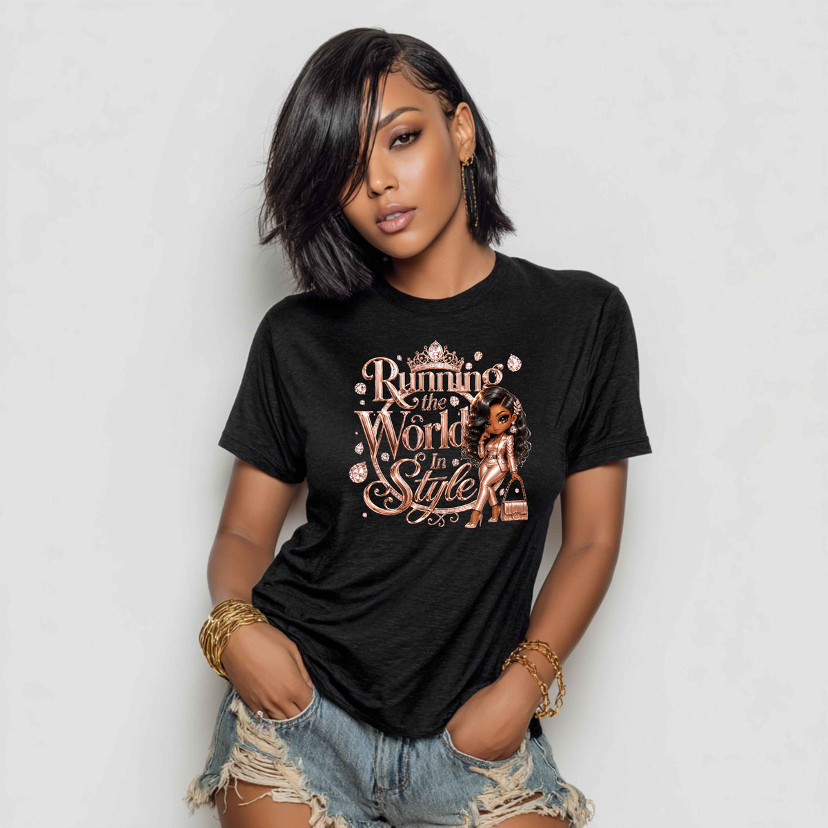 A woman wearing a black graphic t-shirt with a rose gold and white print that reads 'Running to the World in Style' alongside an illustration of a woman, paired with distressed denim shorts.