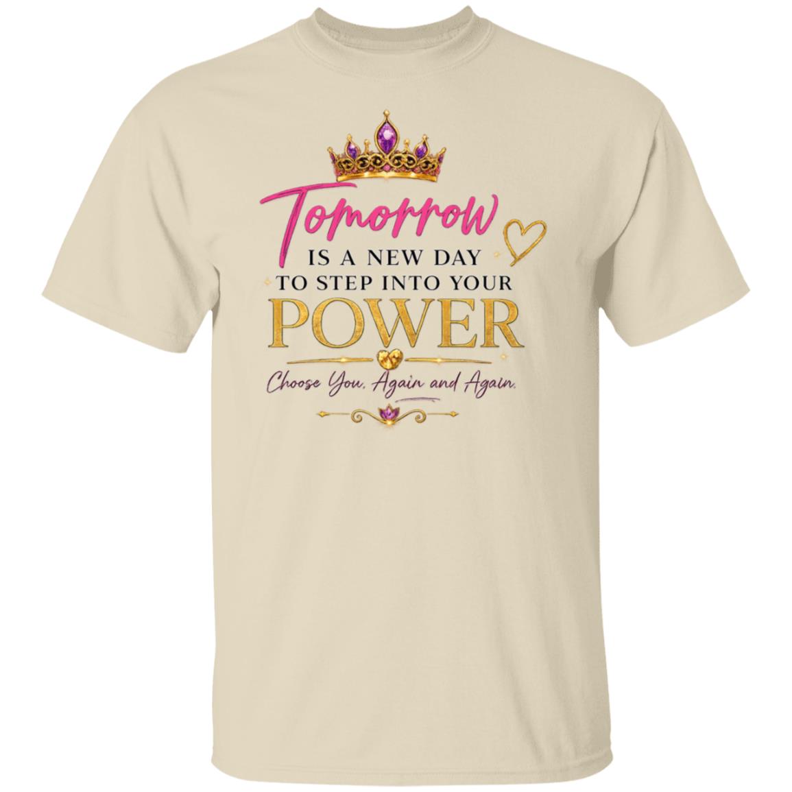 A beige crewneck t-shirt featuring a motivational graphic on the front. The graphic includes a gold crown with purple gemstones, the word 'Tomorrow' in pink script, and the text 'IS A NEW DAY TO STEP INTO YOUR POWER Choose You, Again and Again' in black and gold lettering.