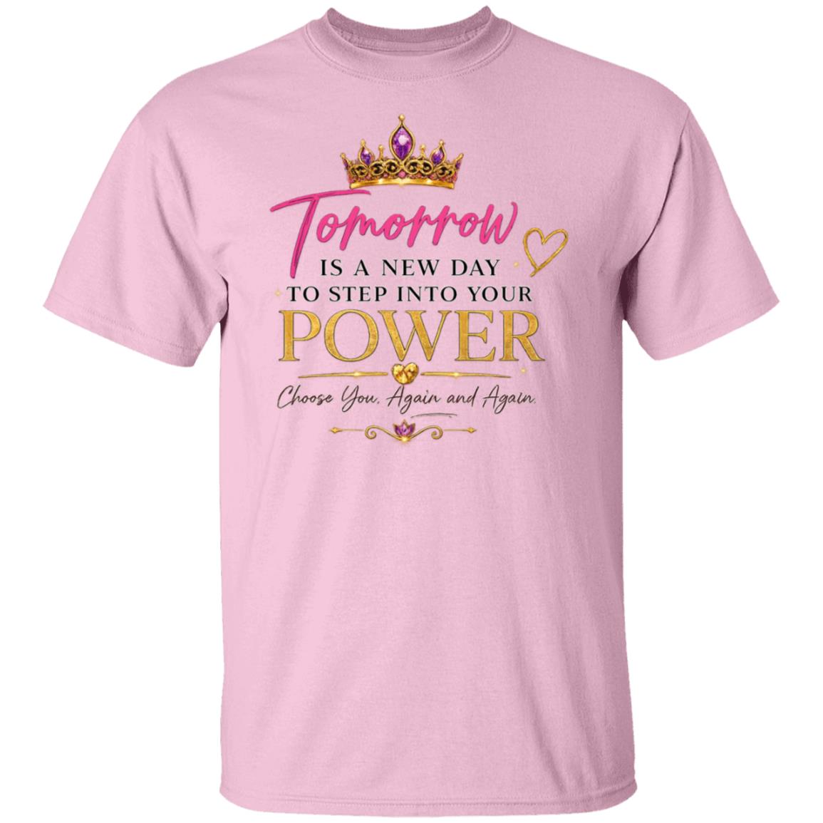 A light pink short-sleeve t-shirt with a graphic print on the front. The design features a gold crown, the word 'Tomorrow' in pink script, and the motivational quote 'Tomorrow is a new day to step into your power Choose you, again and again' in pink, gold, and black fonts.
